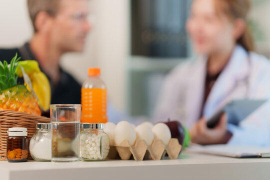 Healthy food and supplements on desk during nutrition consultant session