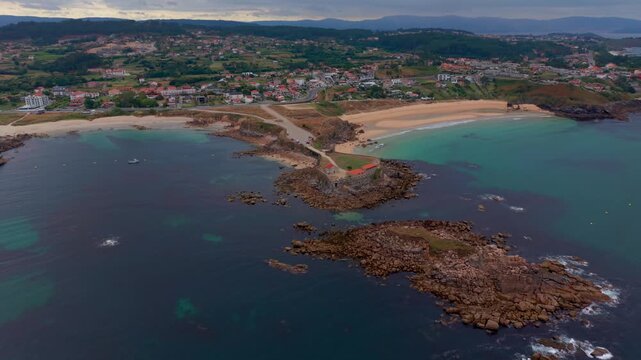Aerial - Capela de Nosa Se&ntilde;ora da Lanzada on a rocky headland between two sandy beaches Galicia