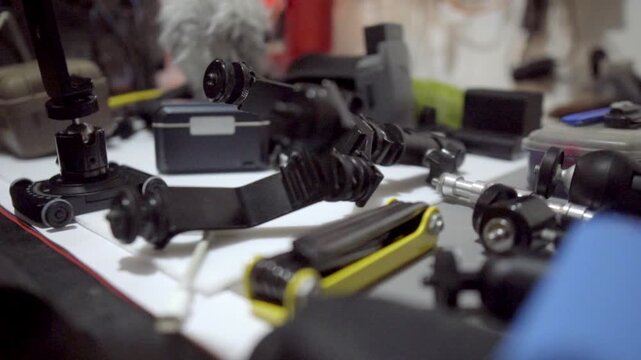 Close up of camera rig accessories and filmmaking equipment arranged on a workbench featuring mounting parts handles brackets and production gear