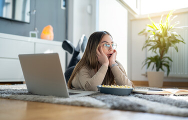 Young female student taking a break from studying at home