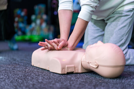 People practicing cardiopulmonary resuscitation CPR and basic life support techniques on a medical training manikin during a first aid course. Emergency response education and lifesaving skills.