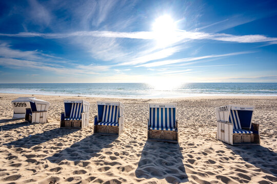 Sunlight illuminates a beach chair on the sand of Sylt