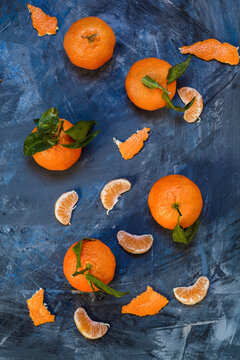 Clementines on blue background, peeled