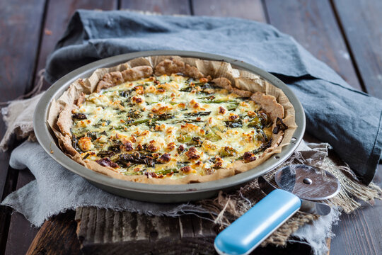 Baking dish of green asparagus tart with feta cheese