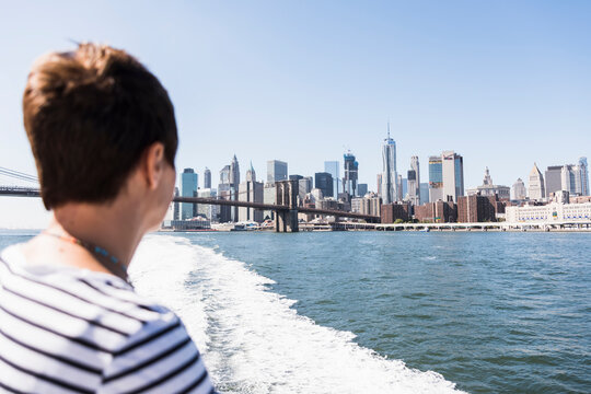 USA, New York City, woman on ferry with Manhattan skyline in background
