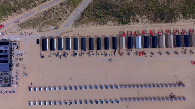 Aerial view video clip of Katwijk aan Zee beach resort top down, beach houses, pavilion terrace, windbreaks, beach cabins, and coastal dune path in South Holland, Netherlands