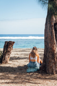Jeune femme assise sur une plage. Touriste en vacances &agrave; la mer. Femme blonde sur l'&icirc;le de La R&eacute;union. Vacances en &eacute;t&eacute;