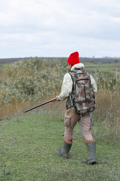 A hunter with a gun in camouflage clothing. A gentleman with a gun, medium shot, unrecognizable.
