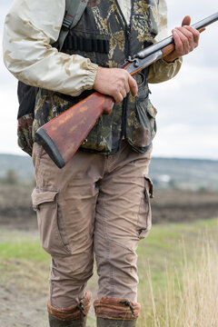 Close-up of a hunter's hand with a gun. Medium shot of a hunter with a weapon.