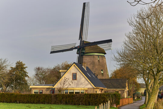 Waarland, North Holland, Netherlands - 26 November 2022: View of the historic Slootgaarpolder mill, a traditional thatched structure with a B and B on the first floor, under an autumn sky.