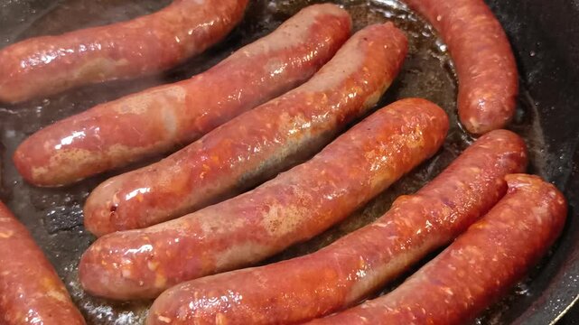 merguez en cuisson, en gros plan, dans une po&ecirc;le