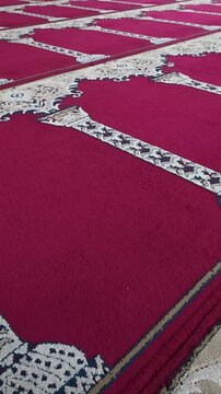 Red mosque prayer carpet with ornate patterned rows