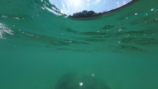 Slow Motion Split View Rocky Sea Coast and Emerald Water
