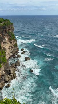 Dramatic coast under Uluwatu Temple. It is a sacred, 10th-century Balinese sea temple perched on a 70-meter-high cliff edge in Pecatu, Bali.