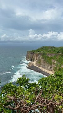 Dramatic coast under Uluwatu Temple. It is a sacred, 10th-century Balinese sea temple perched on a 70-meter-high cliff edge in Pecatu, Bali.