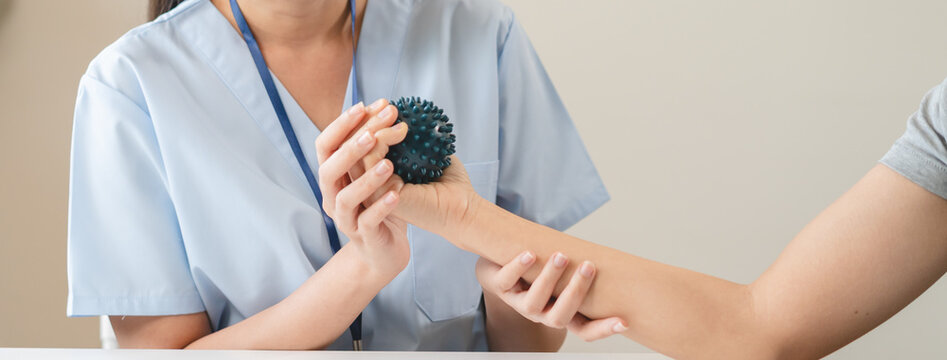 Professional physiotherapist assisting senior patient with hand rehab workout using squeeze stress ball at home medical care service concept