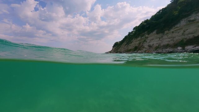Slow Motion Split View Rocky Sea Coast and Emerald Water