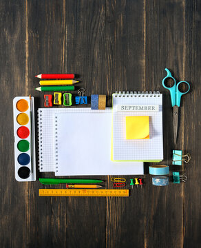 set of accessories, school stationery - pencils, watercolor palette, notebooks on wooden table. Back to school, education, Knowledge Day, 1 september, creativity, artistic art concept. top view