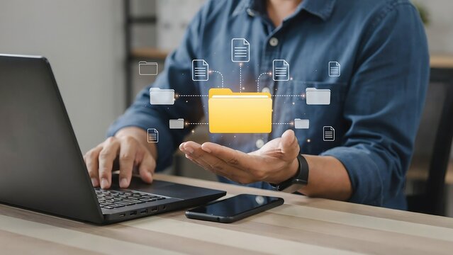 A person organizing digital files on a laptop, with a virtual folder floating above their hand. The scene depicts efficient data management and cloud storage solutions