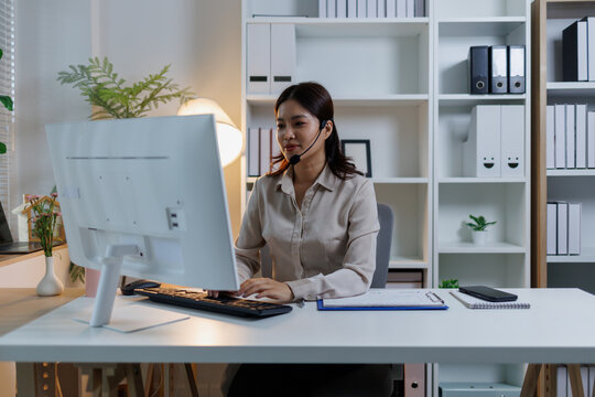 Asian call center agent wearing headset working at home, providing customer service and online support