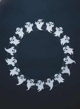 Cute cartoon ghosts arranged in a circular wreath frame for halloween party design