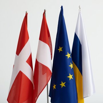 Four European flags stand against a white background to symbolize diplomacy, unity, cultural variety, and global relations.