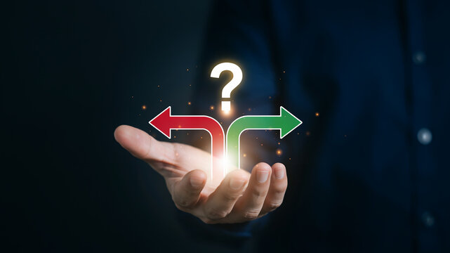 Hand holding a question mark above diverging red and green arrows representing choices