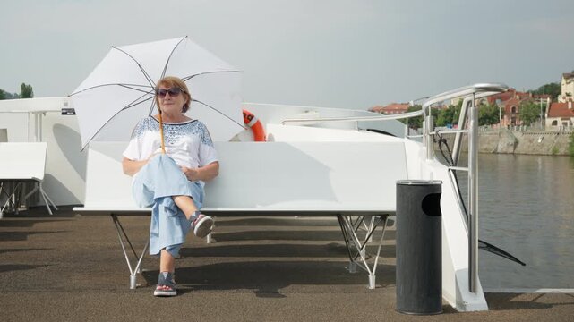 Senior woman relaxes on a boat deck during a luxury cruise. Independent retiree enjoys financial freedom and smart retirement planning. Secure pension investment ensures rich lifestyle.