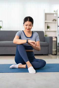 Young woman using smart watch during training indoors. technology and healthy living,