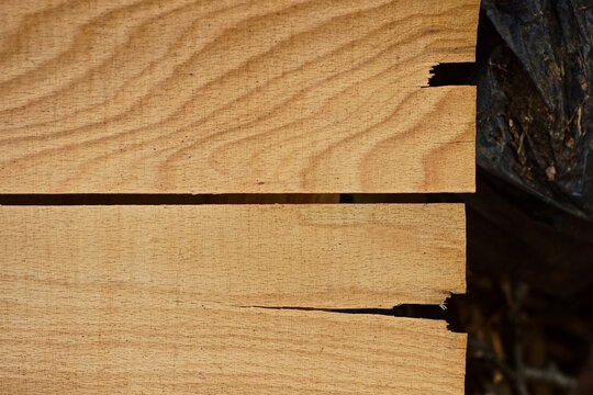 wood texture from a piece of old brown dirty worn and cracks plywood in a wall 