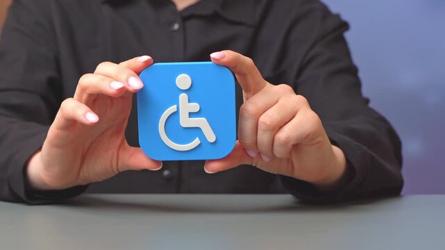 Symbol of disability of a person in the hands of a woman. Workplaces and support for people with disabilities. Inclusive employment, reasonable accommodations and equal opportunity policies