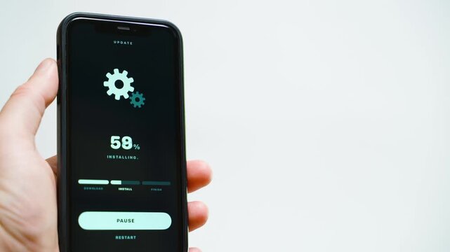 Hand holding smartphone with system update downloading progress on dark screen
