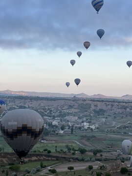 View of hot air balloons floating over the unique rock formations and valleys of Cappadocia, Turkiye.
