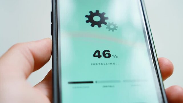 Hands holding smartphone with software update downloading at percent close-up