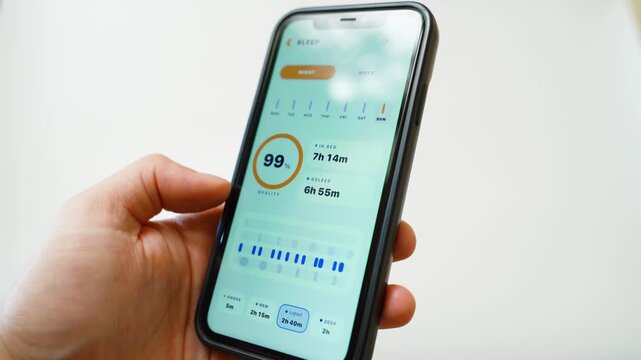 Hand holding smartphone with sleep tracking app showing sleep quality statistics