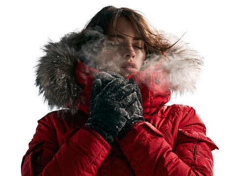 Young woman in red winter jacket with fur hood warming hands and breathing steam isolated on transparent or white background, png