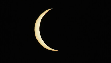 Solar eclipse phase on August 12, 2026, captured in Portugal. Thin crescent of the sun isolated on a black sky background. A rare astronomical celestial event shot © volff