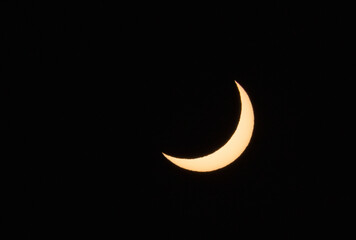 Solar eclipse phase on August 12, 2026, captured in Portugal. Thin crescent of the sun isolated on a black sky background. A rare astronomical celestial event shot © volff