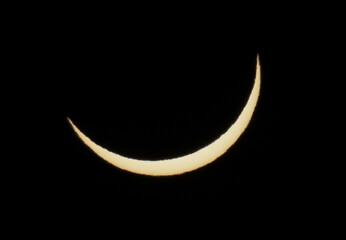 Solar eclipse phase on August 12, 2026, captured in Portugal. Thin crescent of the sun isolated on a black sky background. A rare astronomical celestial event shot © volff
