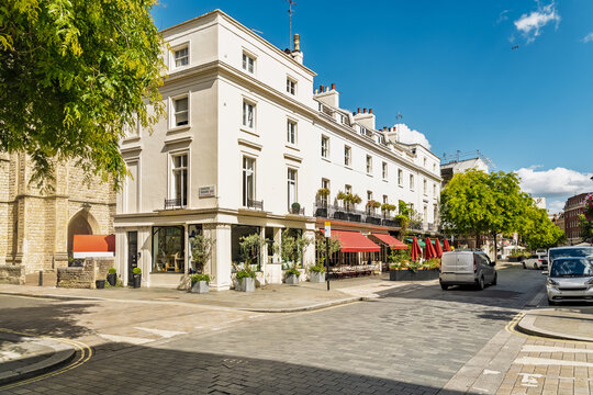 View of the elegant white stucco buildings and red awnings of a street in Belgravia, London, England, United Kingdom.