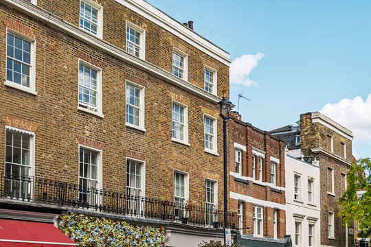 View of historic brick townhouses with classic sash windows and black iron railings in the Belgravia district of London, England, United Kingdom.