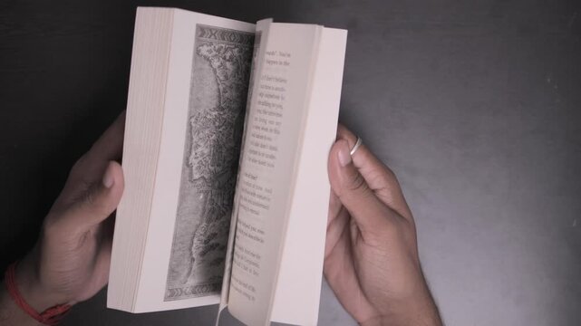 Hands Flipping Through an Open Book.