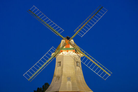 Traditional windmill structure rotating against blue sky
