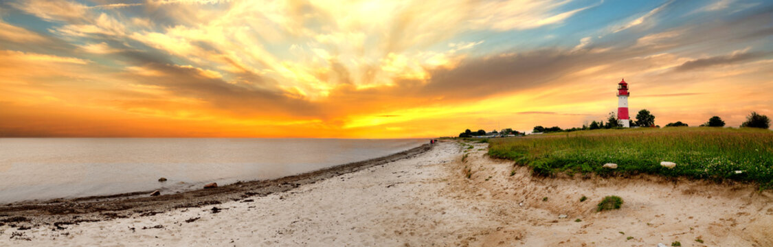 Panorama of sunset at Falsh&ouml;ft lighthouse with sandy beach and colorful evening sky, Germany
