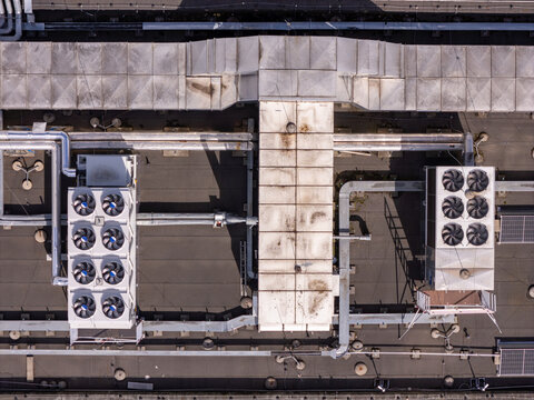 Aerial view of the industrial roof of a data center featuring large HVAC cooling units, ventilation ducts, and complex piping systems in Gdansk, Poland.