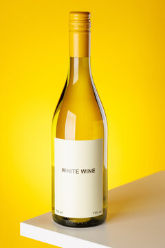 White wine bottle on yellow background minimal studio product shot