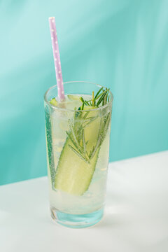 Minimal fresh cucumber drink with herbs on blue background