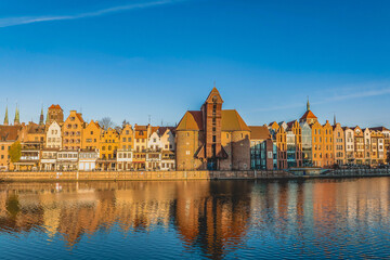 Historic medieval Crane (Żuraw) on the Motława River in Gdańsk, Poland, one of the city's most recognizable landmarks, featuring its distinctive wooden lifting structure and Gothic brick architecture. © Kamil