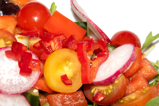 Close up of a delicious healthy side salad with leaves and radish on a white plate