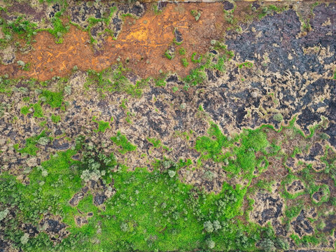 Aerial view of charred land with patches of green vegetation and exposed soil in Banjarbaru, South Kalimantan, Indonesia.